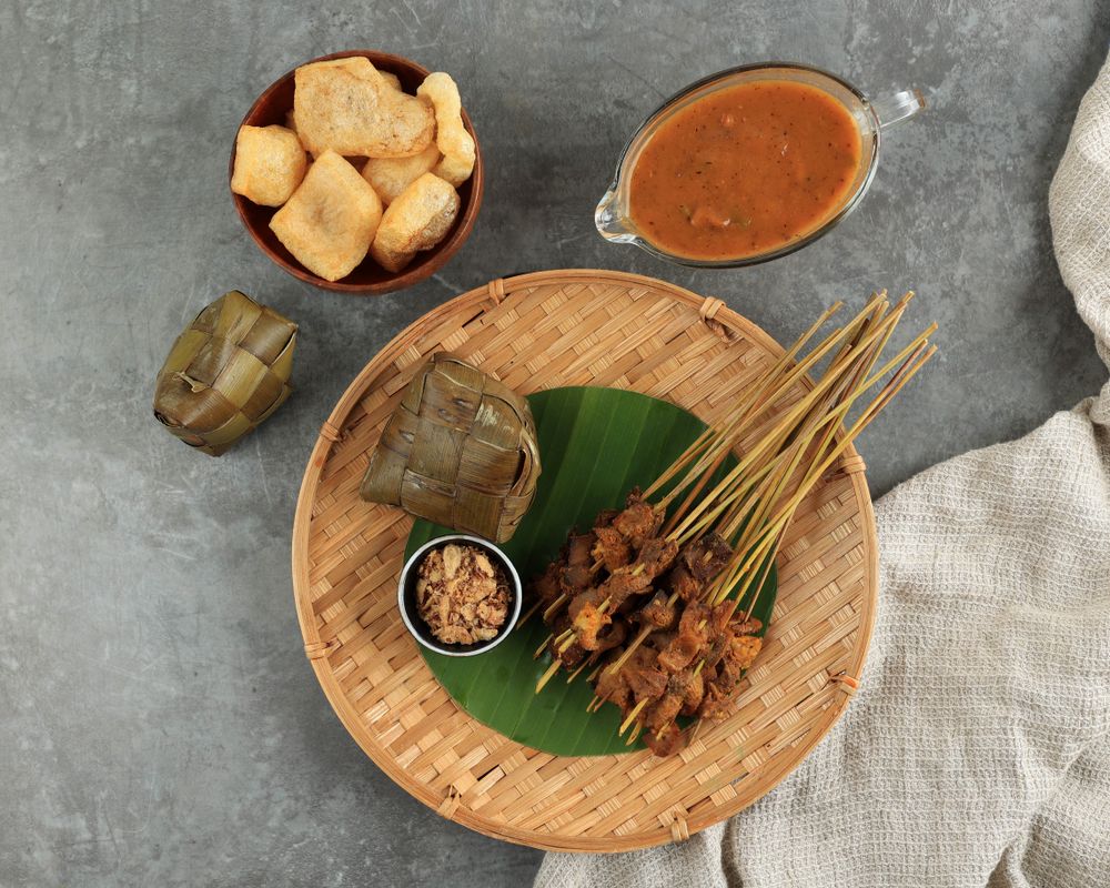 Top view of beef sate skewers served with spicy peanut sauce