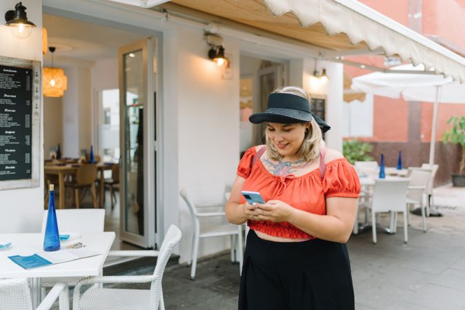 Young woman using smartphone in street cafe