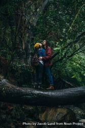Young man hugging woman while standing on a log in the rain 4dr1Q0