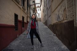 Joyful Asian resting female hiking on old rocked narrow street