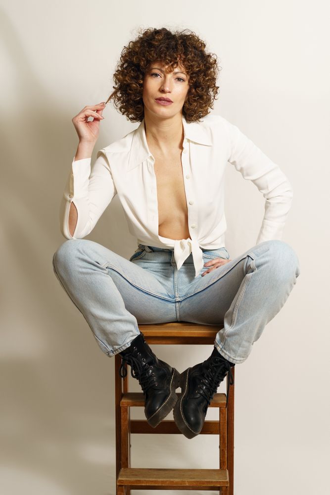 Woman playing with hair on wooden step ladder
