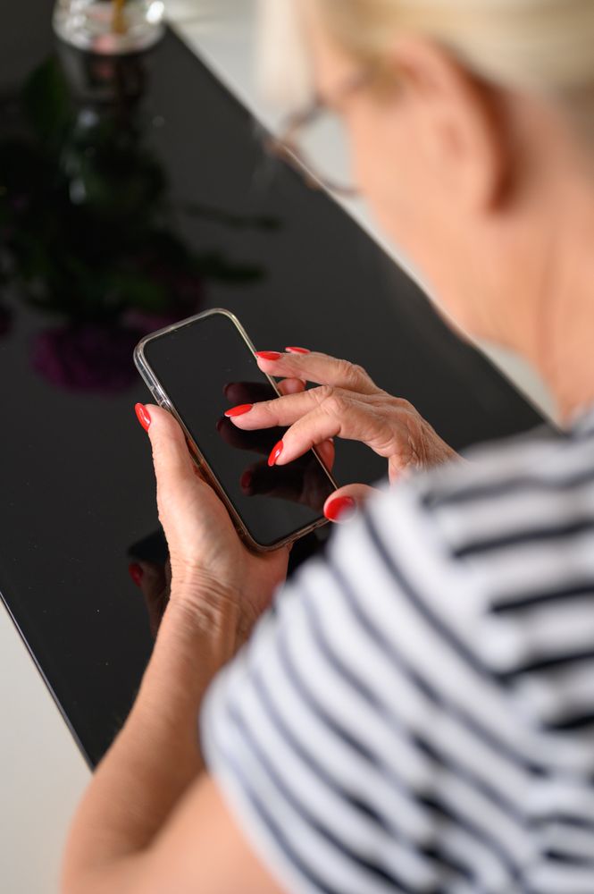 Crop woman using smartphone at home