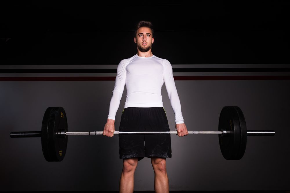 Man lifting barbell in gym