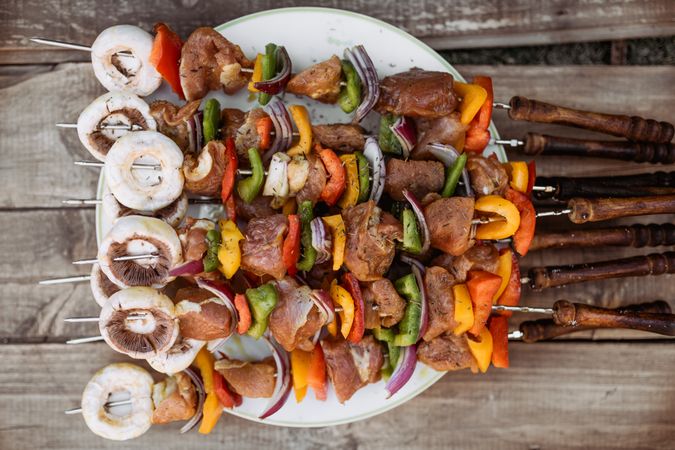 top view of plate with skewers sticks of pork with vegetables
