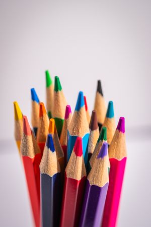 A bunch of colored pencils are lined up in a row