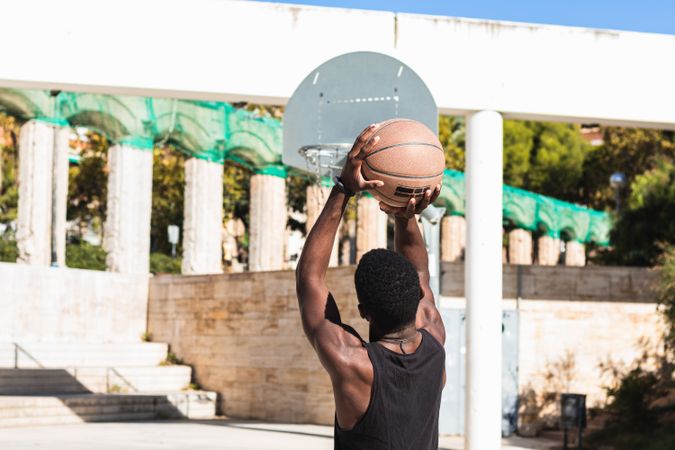 Anonymous Black man playing basketball on sports ground