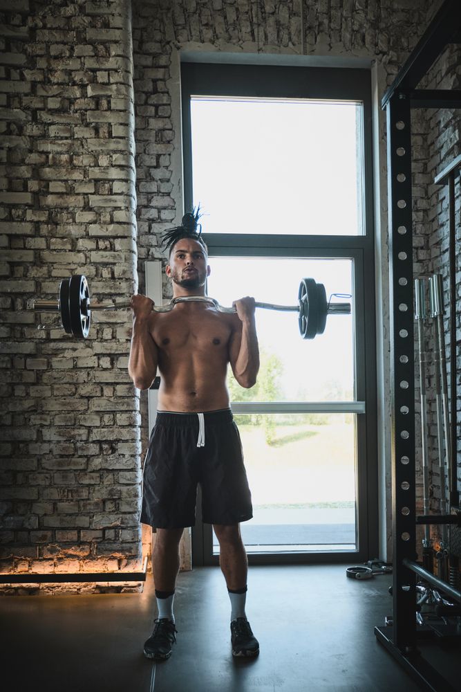 Black man exercising with barbell in gym