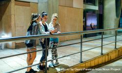 Smiling sporty women looking at cellphone while leaning on banister after training at night 5Q2xAX