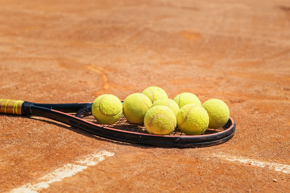 Tennis racket and ball on a dirt court