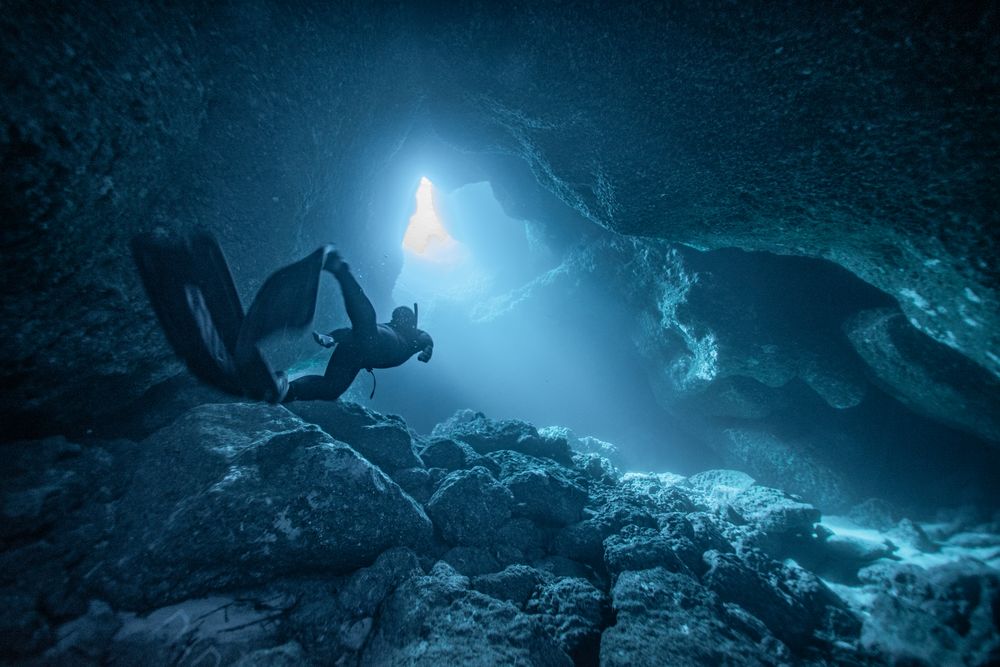 Person diving between rocks