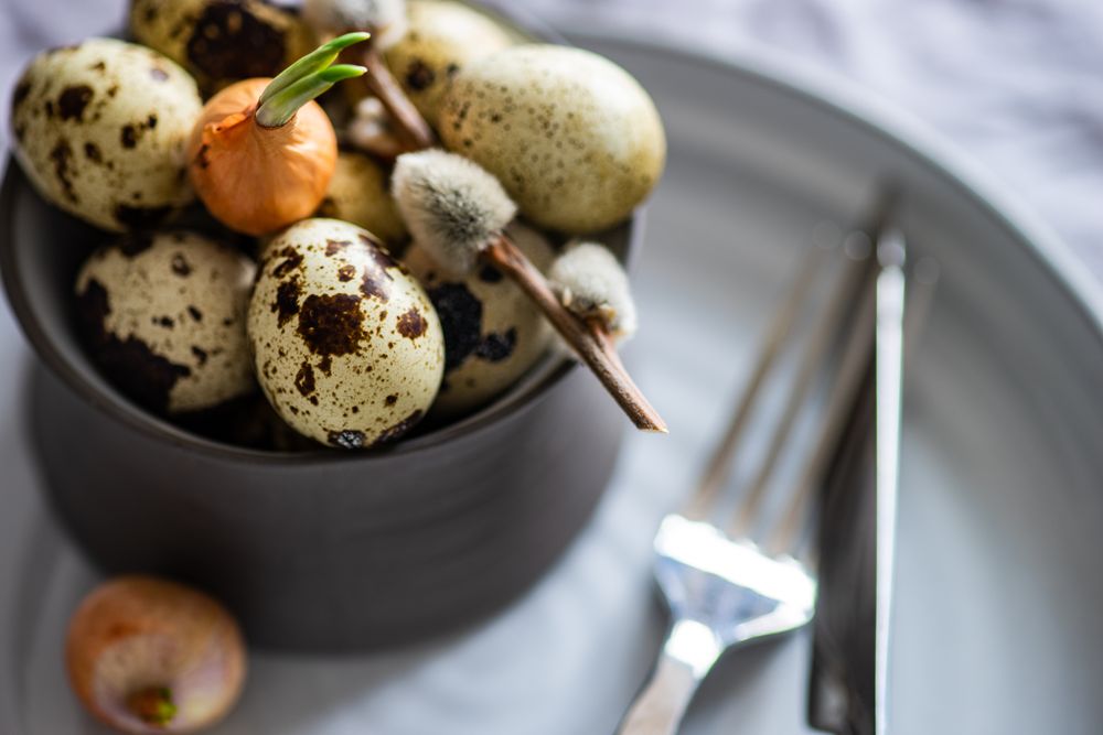 Close up of decorative cup of speckled mini eggs on table setting