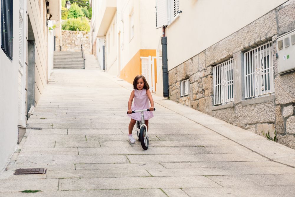 Girl riding on bicycle in narrow street