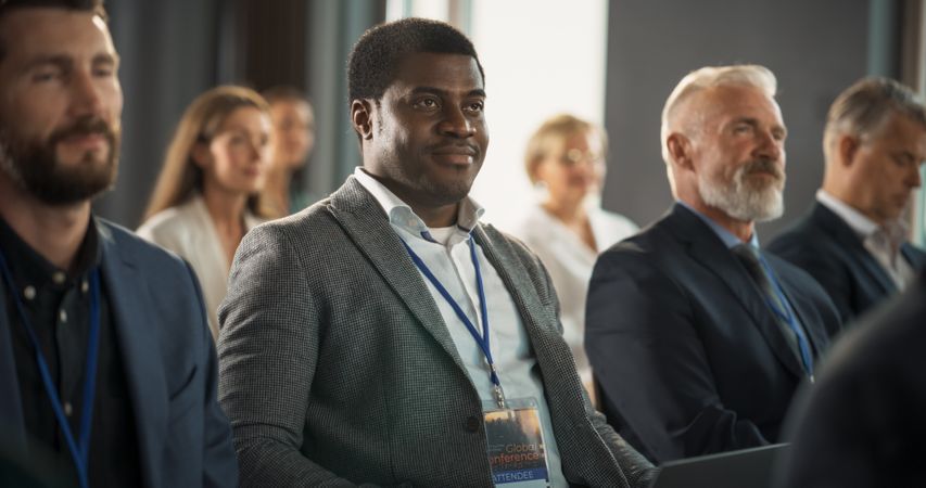 Black Man Sitting in a Crowded Audience at Business Conference.