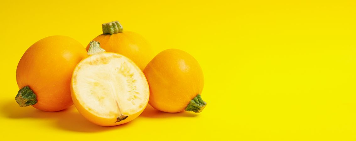 Round zucchini on yellow background, space for text