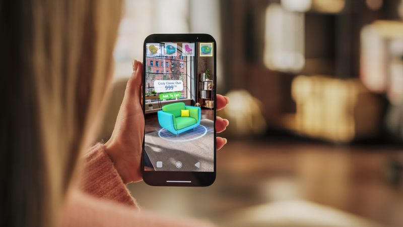 Decorating Apartment: Woman Holding Smartphone, using Augmented Reality Interior Design Software Chooses 3D Furniture for Home. Pick a Stylish Chair for the Living Room.