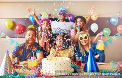 Friends with confetti, novelty glasses, drinks and cake at birthday party 47p6gb