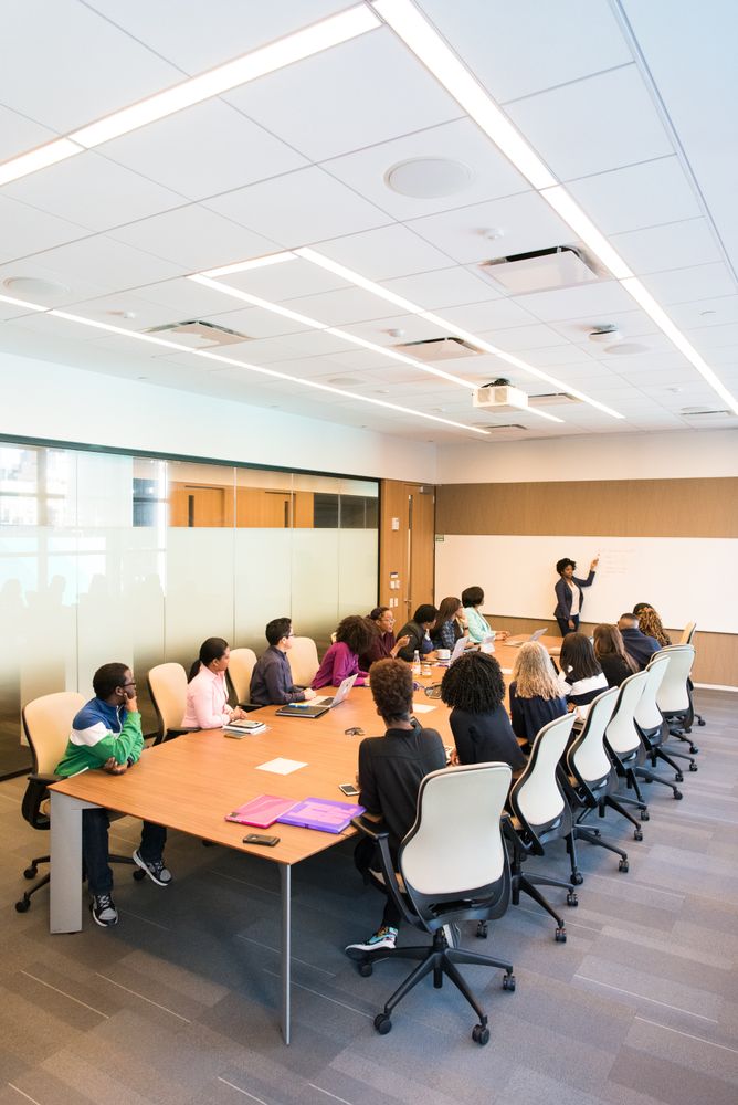 Employees at a meeting lead by businesswoman