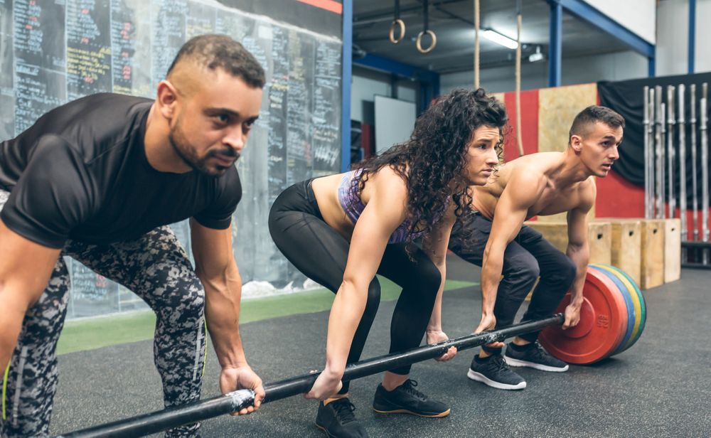 Multiracial team lifting weights in gym