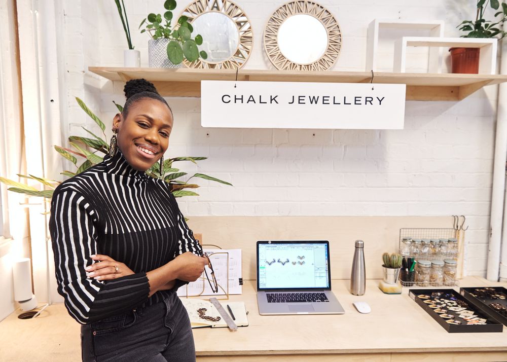 Woman standing and smiling at her jewelry stall