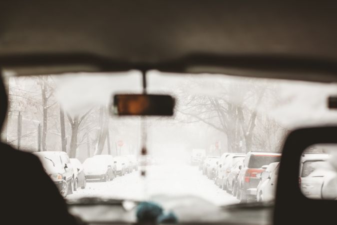 Interior shot of car while person driving on snow covered road