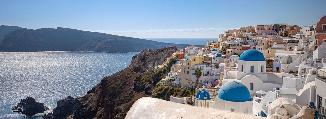 Wide shot of Greek buildings overlooking the Aegean Sea