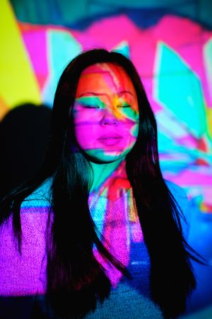 Asian woman under colorful lights in studio