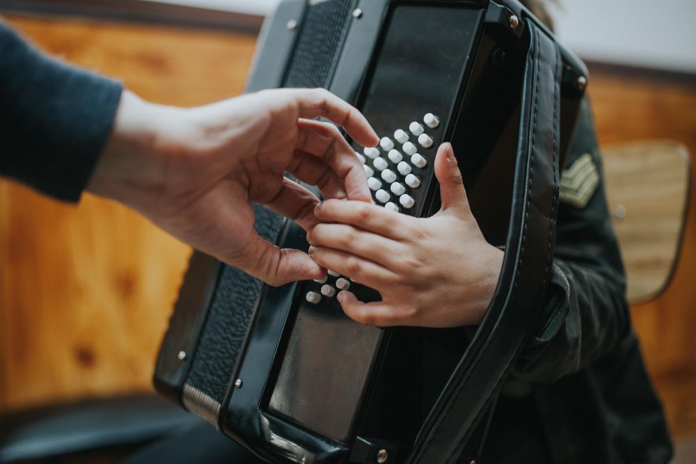 Close up of teacher helping student place fingers on correct notes