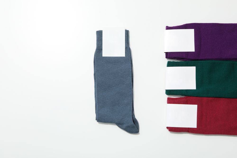 Socks with blank label on light background, space for text