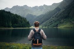 Anonymous man enjoying mountain landscape and lake