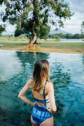 Back of woman in swimsuit standing in pool