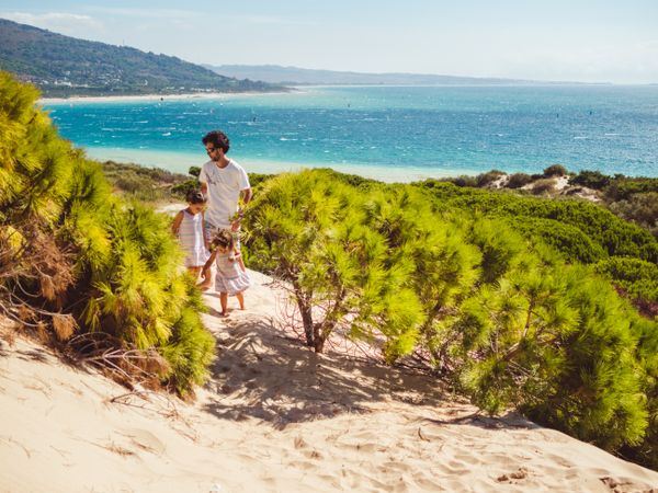 father with children having a stroll at beach