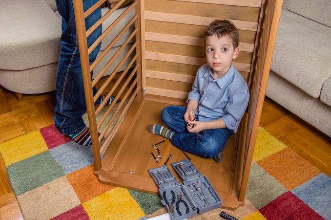 Son and father assembling cot for a newborn at home