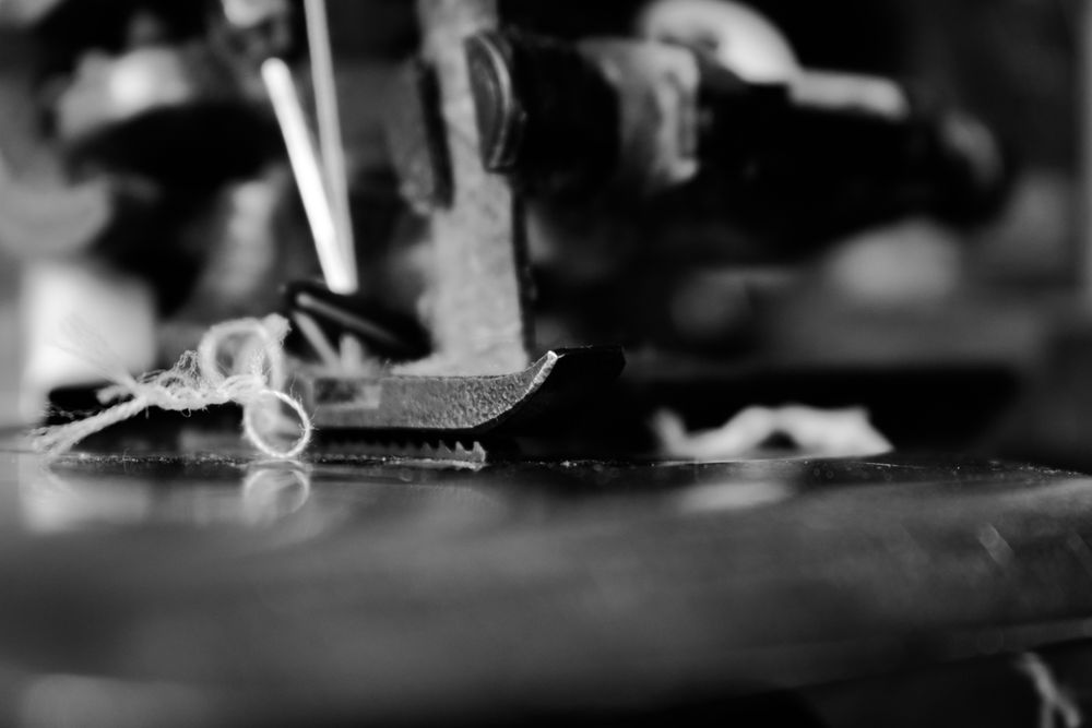 B&W close up of tangled string through sewing machine needle