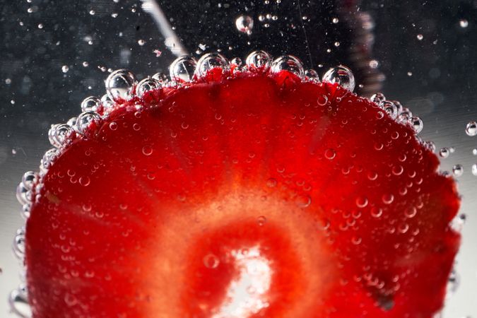 Slice of strawberry covered with bubbles