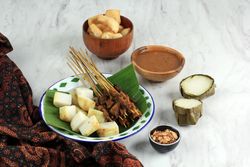 Plate of beef sate skewers served with spicy peanut sauce and rice