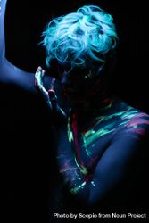 Topless young man with UV body paint in a dark room 47EJP0