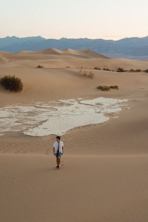 Lonely man walking in sandy desert
