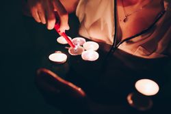 Crop person lighting candles in pool