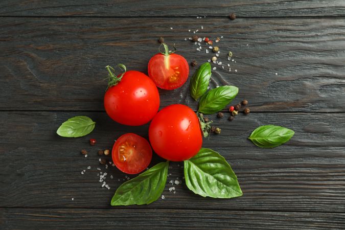 Flat lay composition with fresh tomatoes, salt, pepper and basil on wooden background, space for text. Ripe vegetables