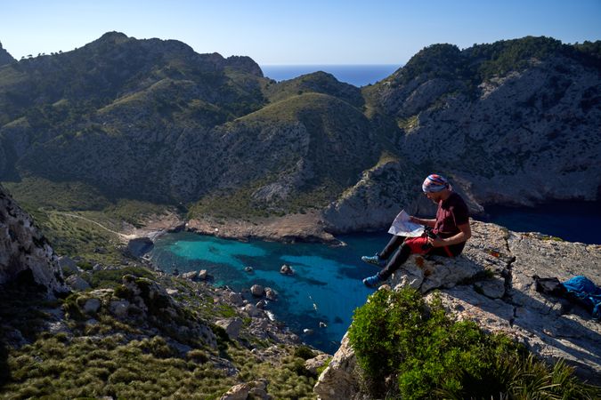 Traveler sitting in mountains in sunny day