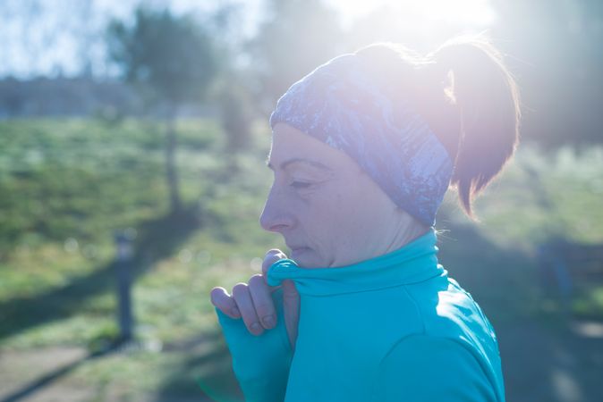 Side view of woman in blue working out on sunny fall day