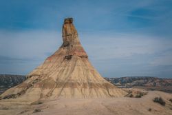 Stone peak in desert against bright sky