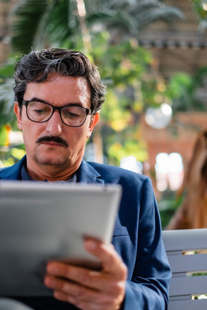 Mature handsome man using digital tablet outdoors