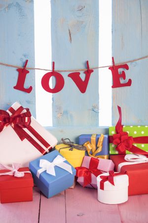 Multicolor gifts and the letters from the word “love” strung on a banner