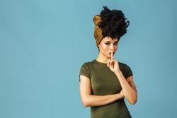 Studio shoot of Black woman making “shush” gesture