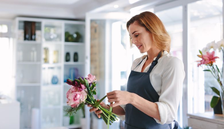 Woman florist preparing a bouquet at her shop