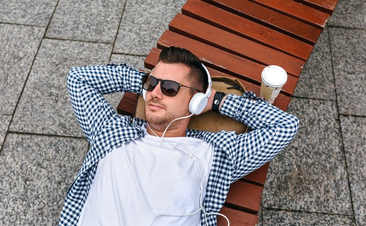 Man with headphones relaxing on a bench