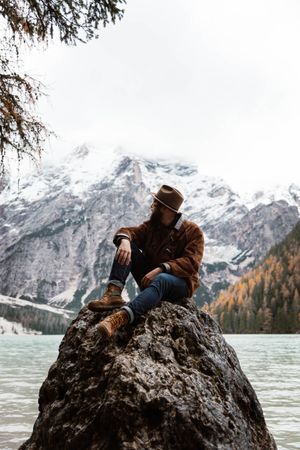 Man delighting in views near lake and mountains