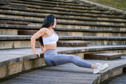 Slim woman doing yoga on street