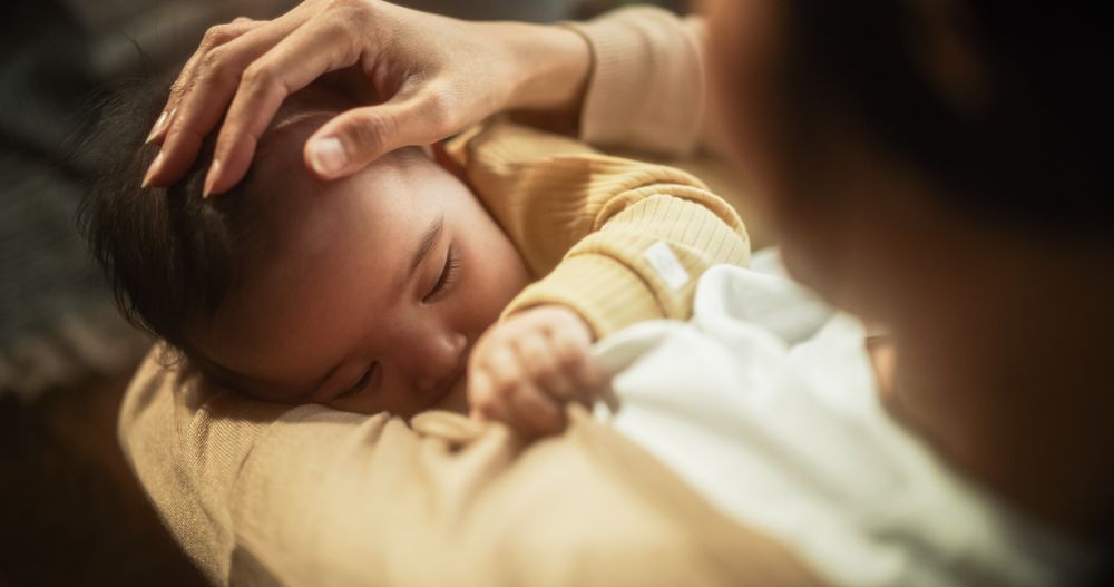 High Angle Portrait of a Cute Asian Baby Feeding from the Breast of Her Mother.